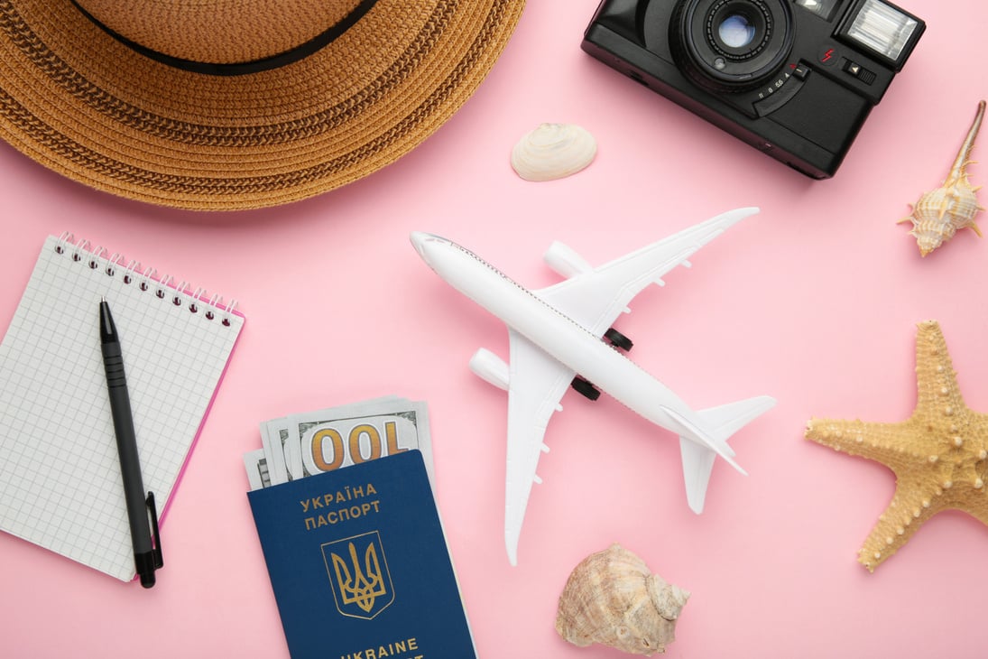 Airplane with Traveler Accessories on Pink Background. Travel Concept