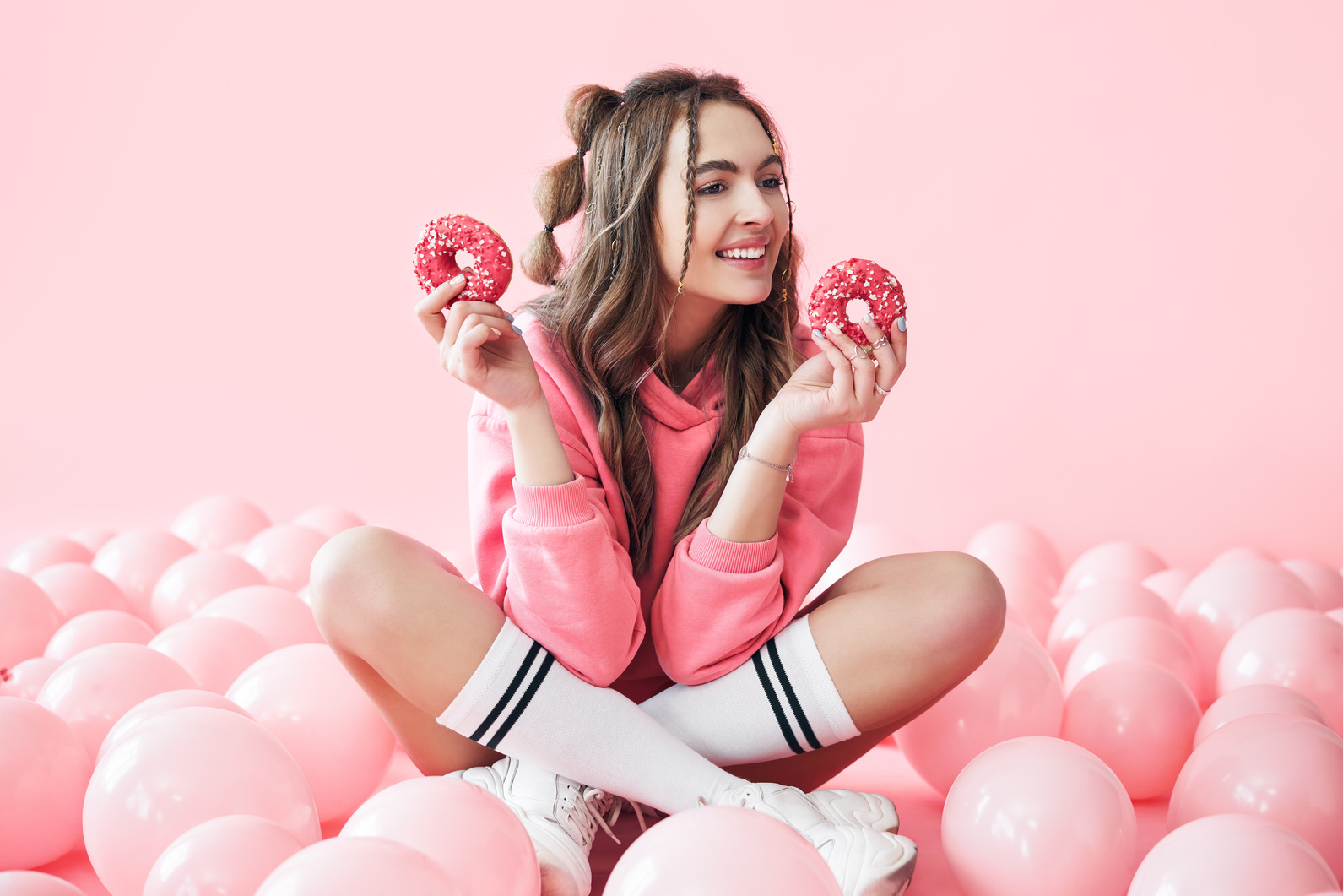 Young Woman Holding Donuts with Pink Balloons