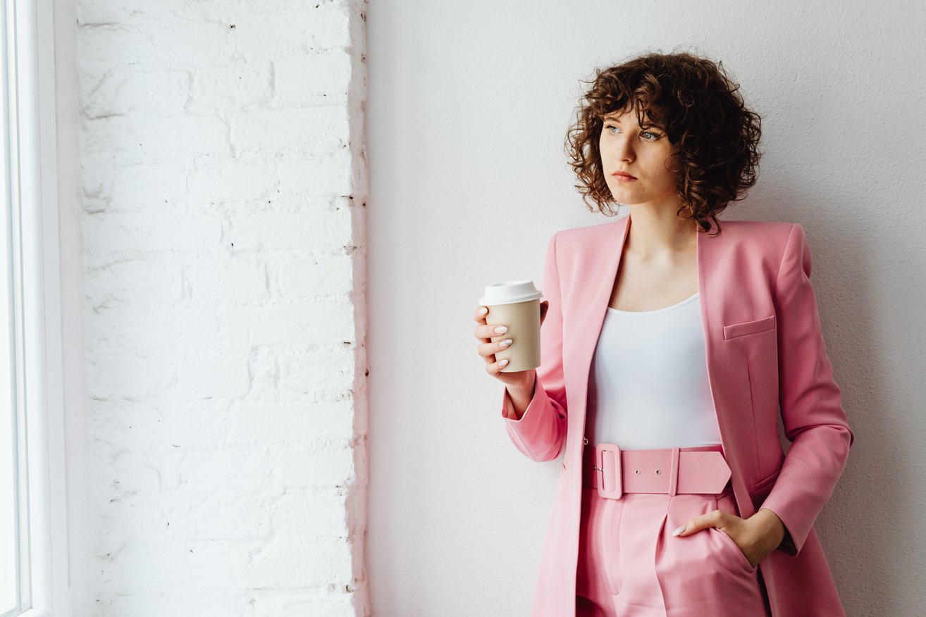 Woman in Her Pink Suit Holding a Coffee